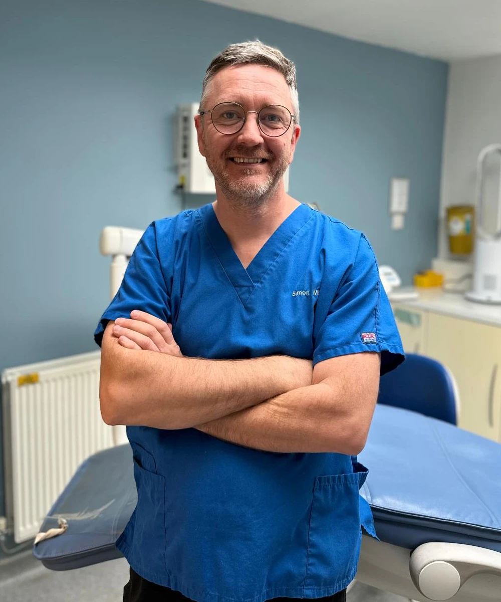Simon Miles in blue scrubs at the clinic